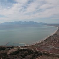 Aerial view of the area where the modern and the ancient port, the archaeological site of Abdera and Polystylon are visible down on the rirgt, as well as the island of Thassos in the background.